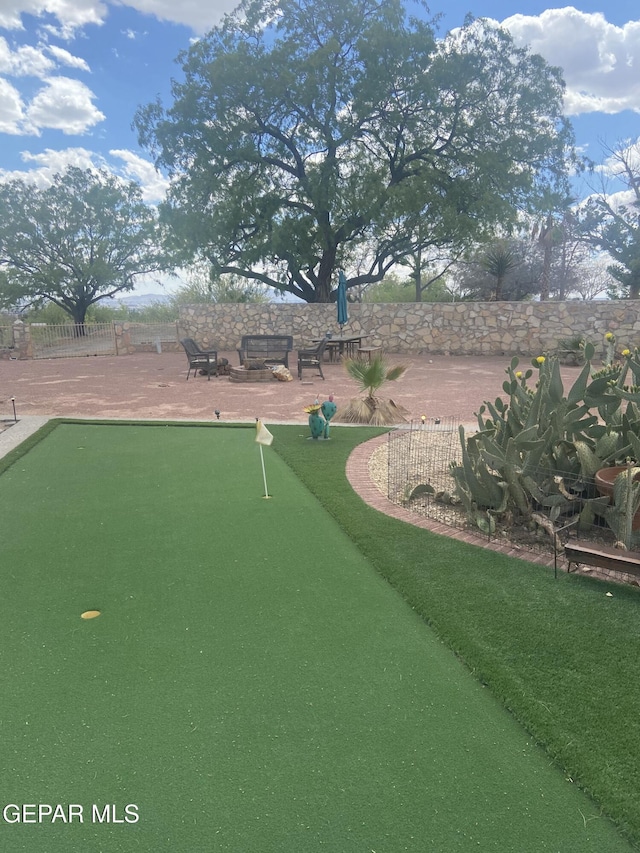 view of home's community with a putting green, fence, and a patio