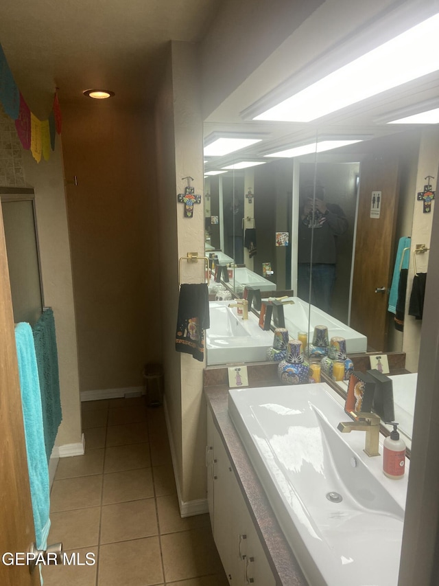 bathroom with tile patterned flooring, baseboards, and vanity
