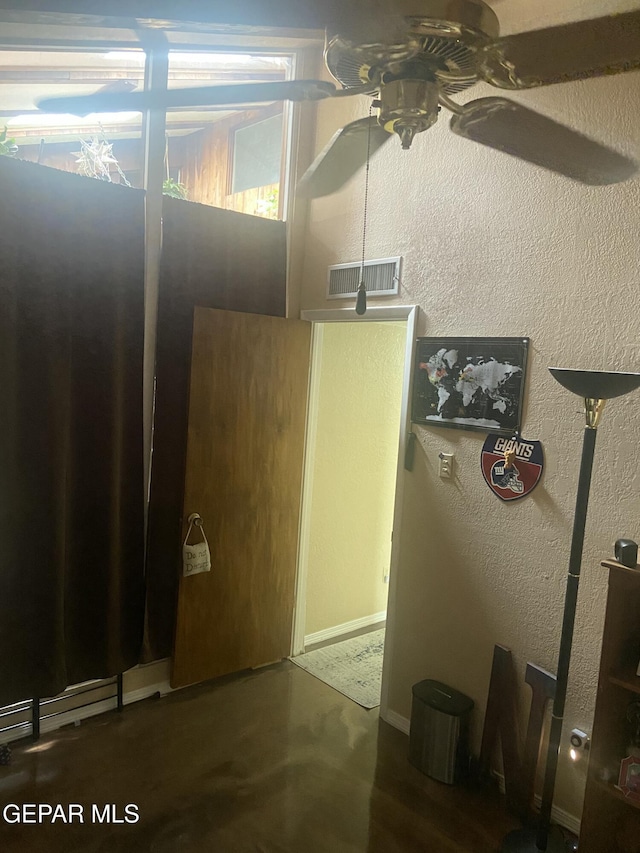 spare room with a ceiling fan, baseboards, and a textured wall