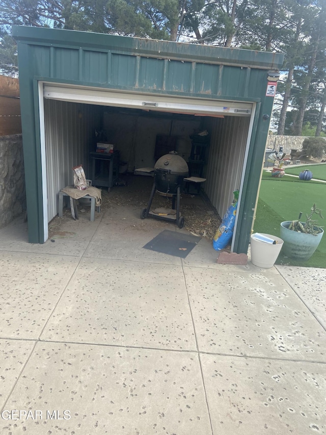 garage featuring concrete driveway