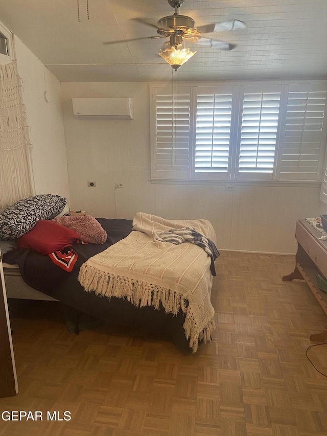 bedroom featuring a wall mounted AC and a ceiling fan