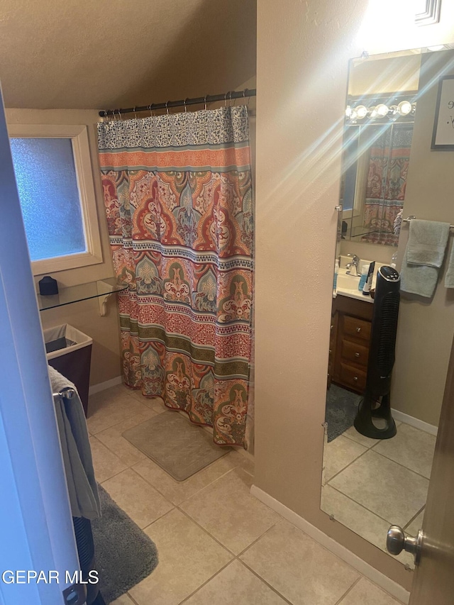 full bathroom with tile patterned flooring, vanity, baseboards, and curtained shower