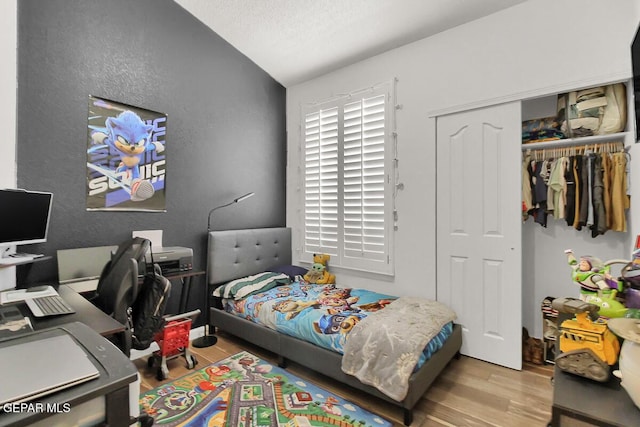 4729 Joseph Rodriguez Dr, El Paso, TX 79938 - bedroom with wood finished floors, a desk, a closet, vaulted ceiling, and a textured wall