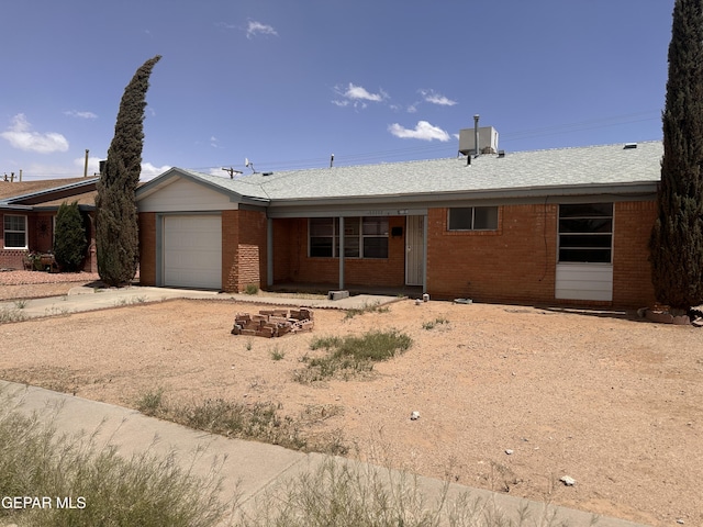 single story home with a garage, brick siding, and concrete driveway