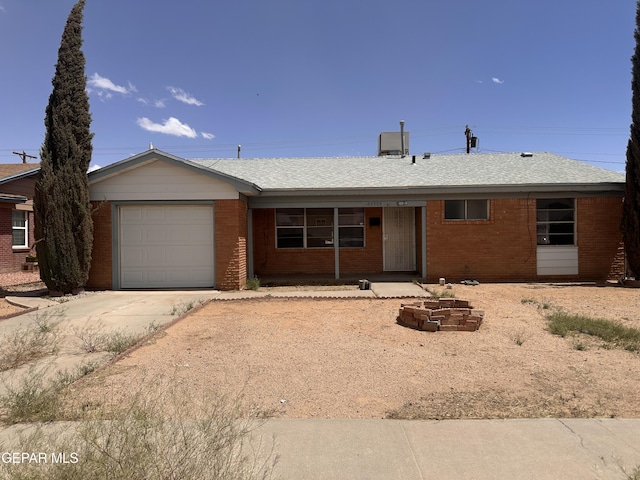 single story home with a garage, driveway, and brick siding