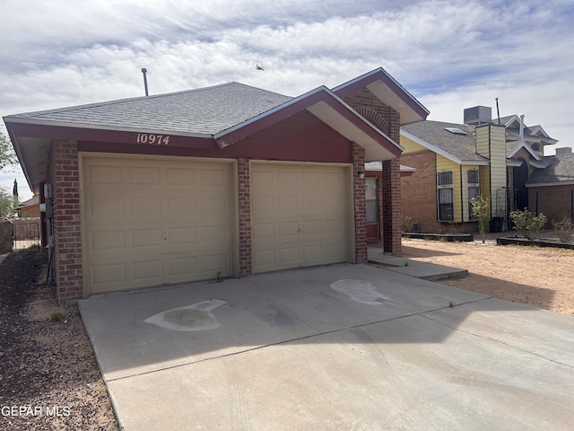 view of front of property featuring driveway, brick siding, an attached garage, and a shingled roof