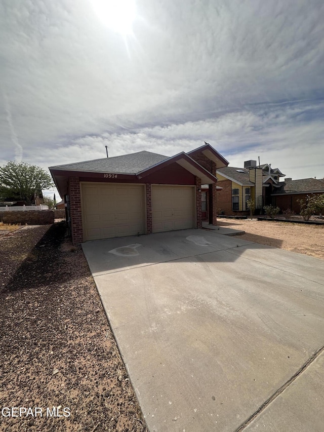 view of front of property featuring a garage, driveway, and brick siding