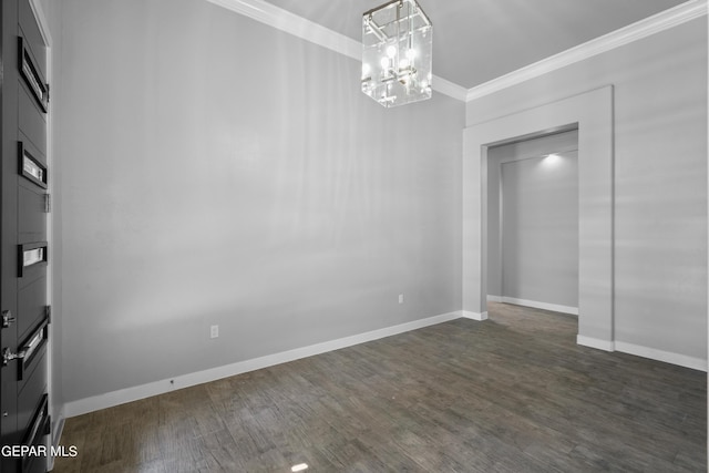empty room with crown molding, a chandelier, dark wood-style flooring, and baseboards