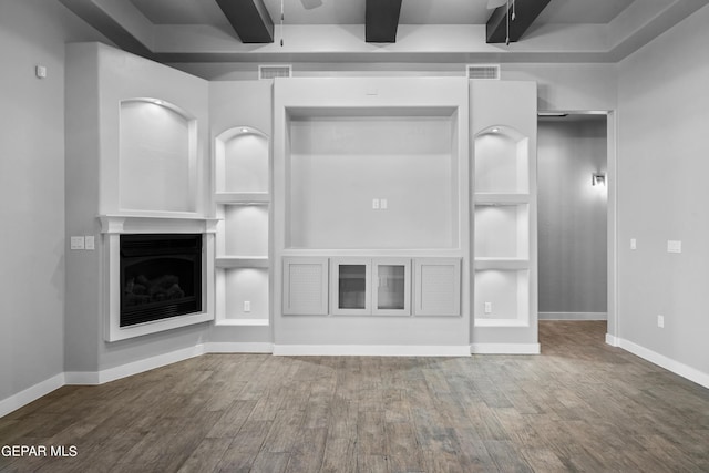 unfurnished living room with wood finished floors, beamed ceiling, ceiling fan, a fireplace, and baseboards