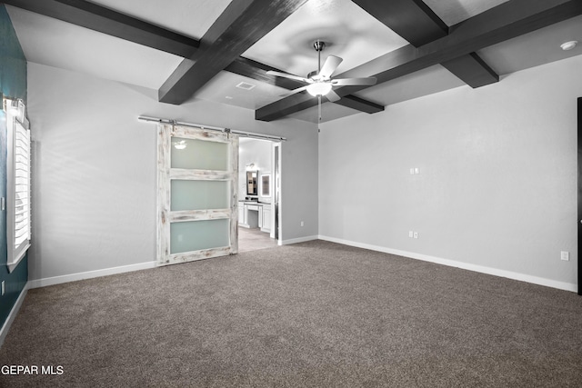 empty room featuring a barn door, ceiling fan, beamed ceiling, carpet floors, and baseboards