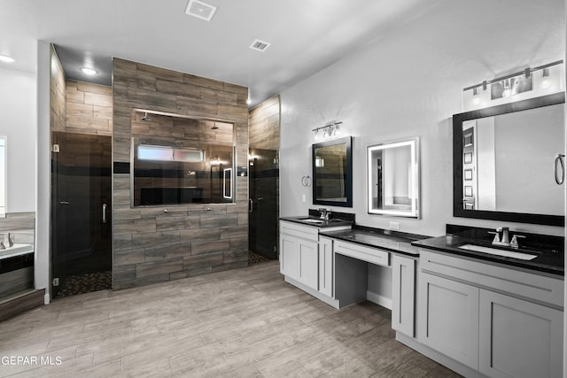 bathroom with a stall shower, wood finished floors, and vanity