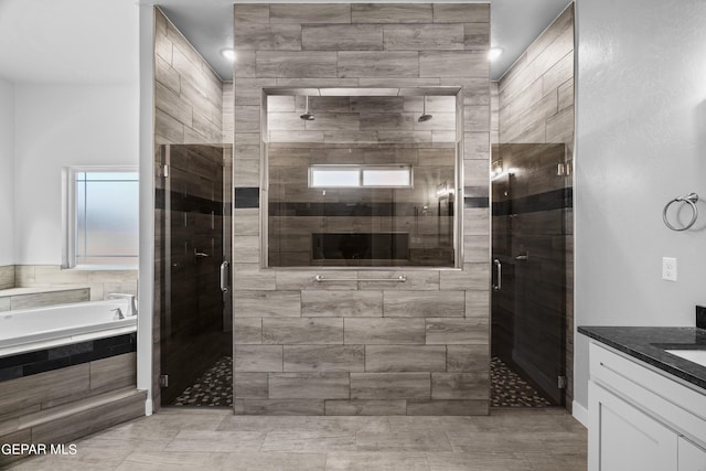 bathroom featuring a garden tub, a shower stall, vanity, and tile patterned floors