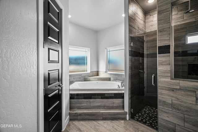 bathroom featuring a shower stall, a bath, wood finished floors, and recessed lighting