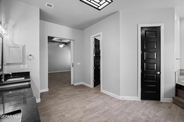 bathroom featuring vanity, ceiling fan, wood finished floors, and baseboards
