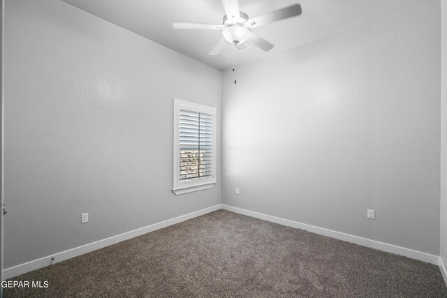 unfurnished room with dark carpet, a ceiling fan, and baseboards