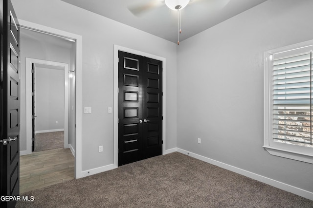 entrance foyer with ceiling fan, carpet, and baseboards