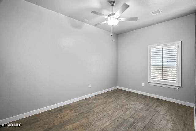 unfurnished room with a ceiling fan, dark wood-type flooring, and baseboards
