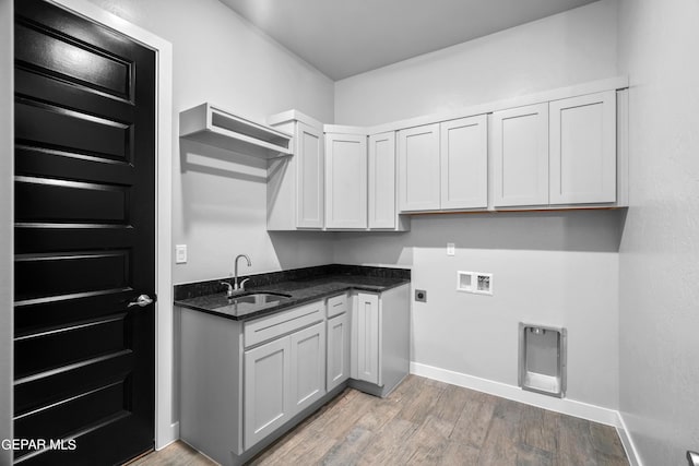 washroom featuring washer hookup, hookup for an electric dryer, light wood-type flooring, and baseboards