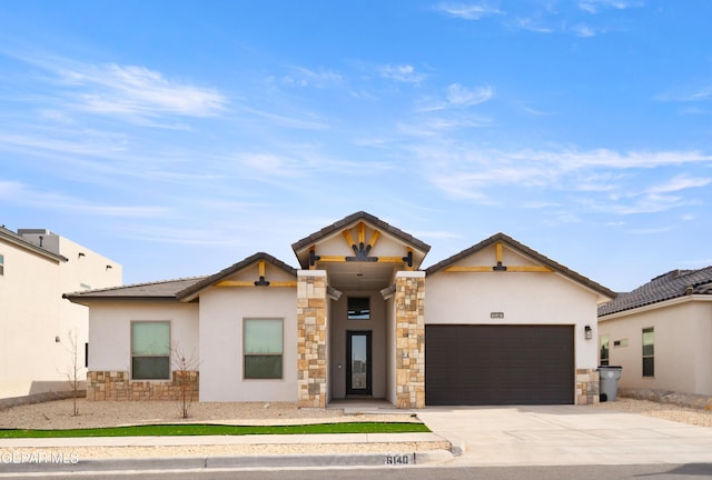 view of front facade with stone siding, stucco siding, an attached garage, and driveway
