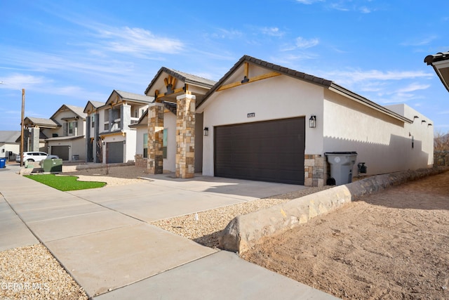 view of front of property with concrete driveway, a garage, stone siding, a residential view, and stucco siding