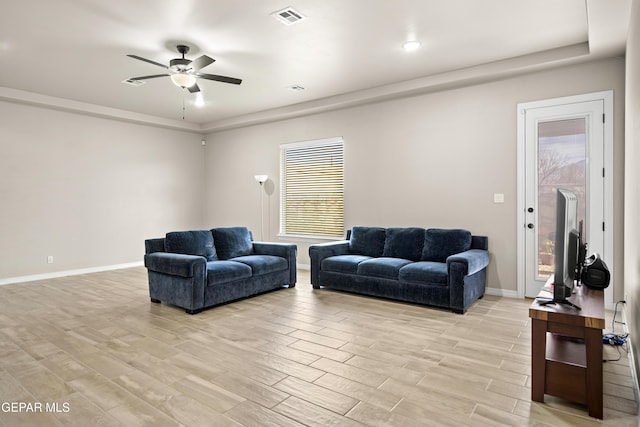 living area with a ceiling fan, light wood-style flooring, and baseboards