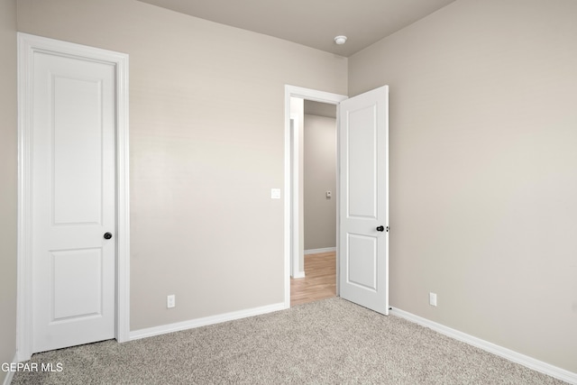 unfurnished bedroom with carpet flooring and baseboards
