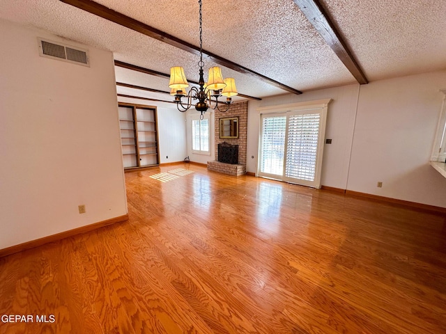 3100 Hector Dr, El Paso, TX 79935 - unfurnished living room featuring a textured ceiling, a chandelier, beamed ceiling, baseboards, and light wood-style flooring
