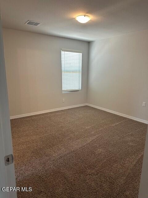6112 Hidden Row Ave, El Paso, TX 79924 - empty room featuring dark carpet and baseboards