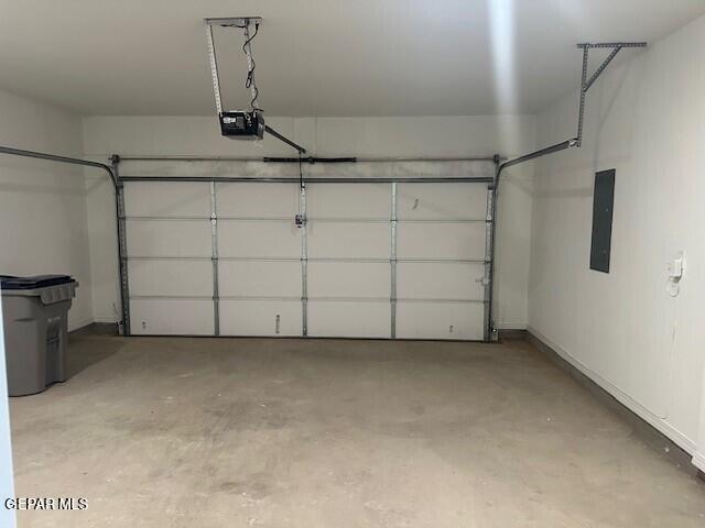 6112 Hidden Row Ave, El Paso, TX 79924 - garage with electric panel, a garage door opener, and baseboards