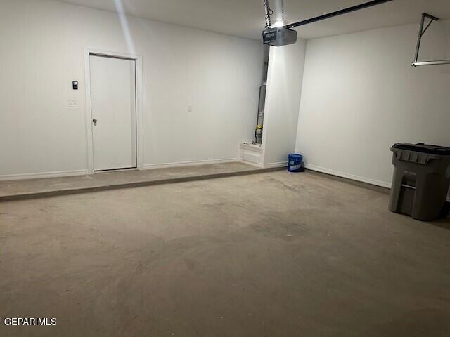 6112 Hidden Row Ave, El Paso, TX 79924 - garage featuring a garage door opener and baseboards