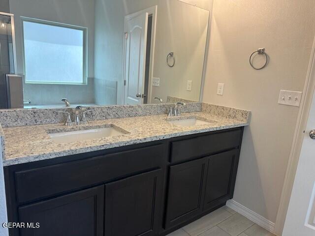 6112 Hidden Row Ave, El Paso, TX 79924 - bathroom with tile patterned flooring, double vanity, and baseboards