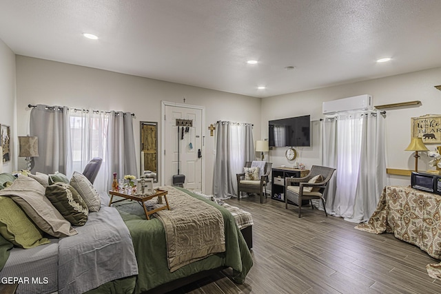 3244 Richmond Ave, El Paso, TX 79930 - bedroom featuring an AC wall unit, wood finished floors, recessed lighting, and a textured ceiling