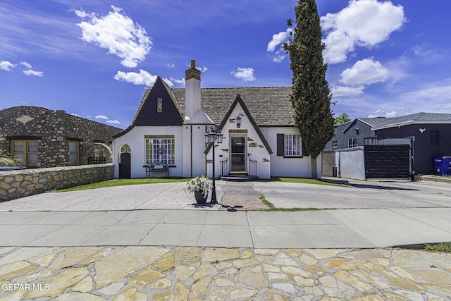 3244 Richmond Ave, El Paso, TX 79930 - view of front of house with stucco siding, curved driveway, a chimney, a gate, and fence
