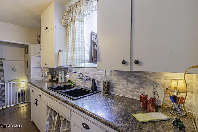 3244 Richmond Ave, El Paso, TX 79930 - kitchen featuring a sink, dark countertops, white cabinets, decorative backsplash, and dark wood-type flooring
