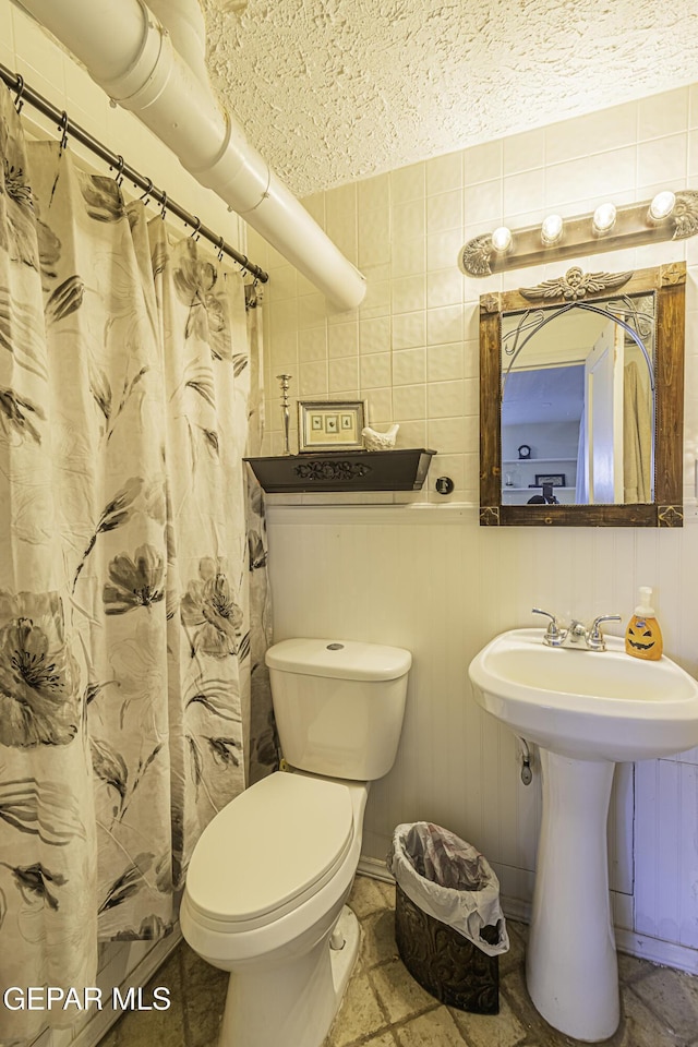 3244 Richmond Ave, El Paso, TX 79930 - bathroom with toilet, a textured ceiling, a shower with curtain, and a sink