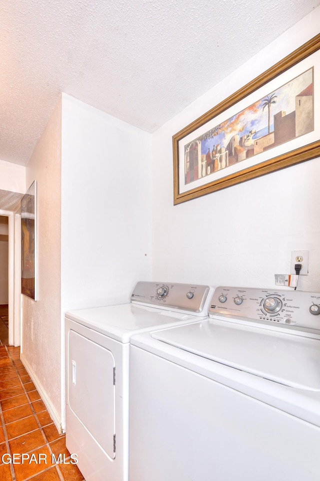 laundry room featuring independent washer and dryer, a textured ceiling, tile patterned flooring, and baseboards
