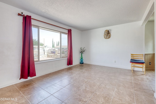 tiled spare room with a textured ceiling