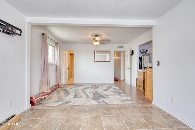 unfurnished room featuring a ceiling fan and baseboards
