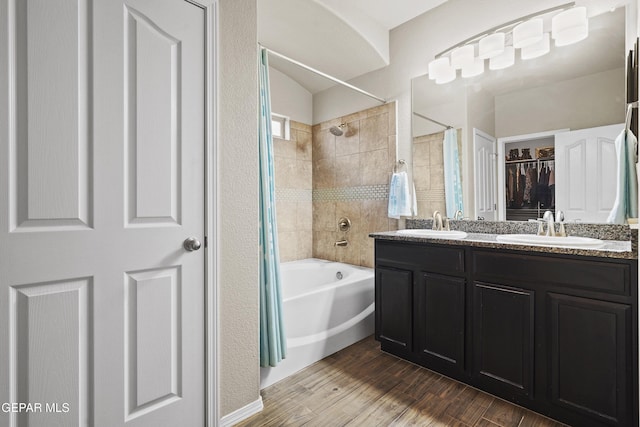 7421 Dewberry Dr, El Paso, TX 79911 - bathroom featuring shower / tub combo with curtain, double vanity, wood finished floors, and a spacious closet