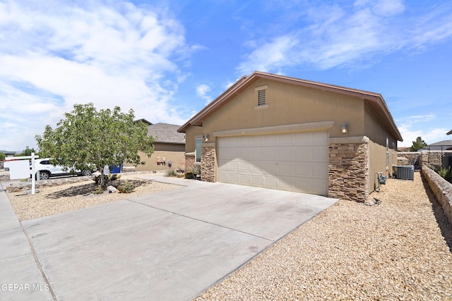 7421 Dewberry Dr, El Paso, TX 79911 - view of front of home with stone siding, stucco siding, driveway, cooling unit, and a garage