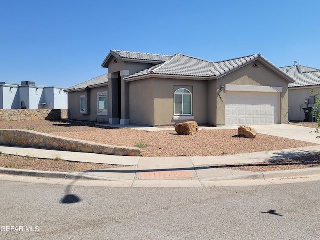 13611 Everingham St, El Paso, TX 79928 - view of front of house with an attached garage, stucco siding, concrete driveway, and a tile roof