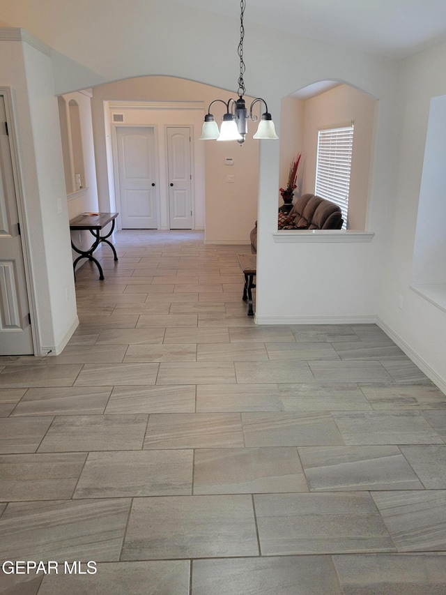13611 Everingham St, El Paso, TX 79928 - unfurnished dining area featuring a chandelier, baseboards, and arched walkways