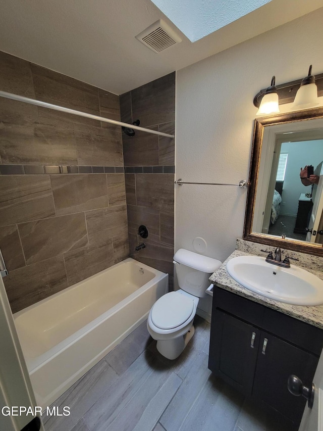 13611 Everingham St, El Paso, TX 79928 - full bathroom with toilet, shower / washtub combination, vanity, a skylight, and wood finished floors