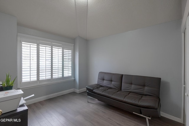 sitting room with plenty of natural light, wood finished floors, baseboards, and a textured ceiling