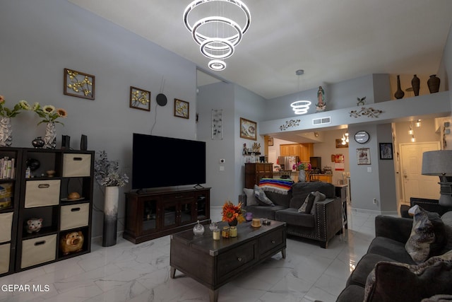 living room with a chandelier and light marble finish floors