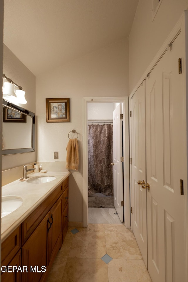 full bath featuring vaulted ceiling and double vanity