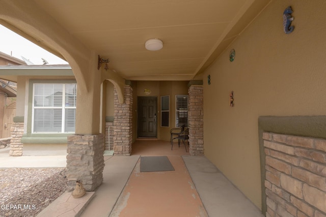 doorway to property featuring stucco siding and stone siding