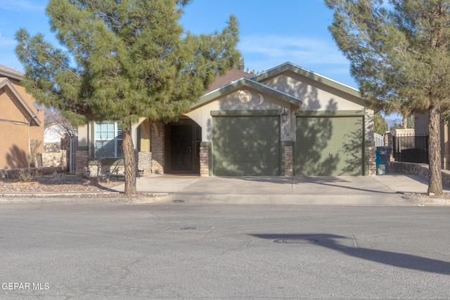 ranch-style house featuring concrete driveway, an attached garage, stucco siding, and stone siding