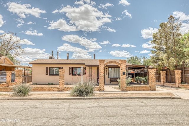 view of front facade featuring stucco siding and fence