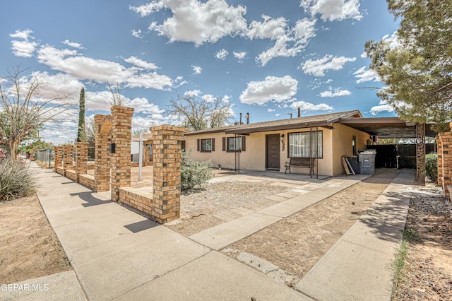ranch-style home with stucco siding and an attached carport